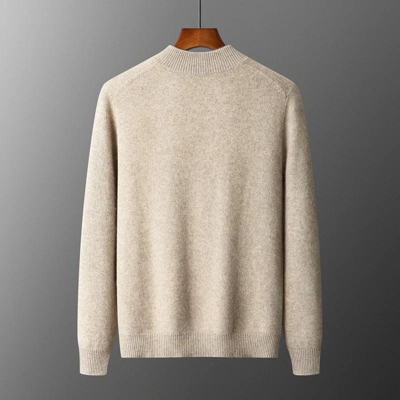 Beige uldtrøje på bøjle mod grå baggrund. Klassisk design, rund hals, lange ærmer. Perfekt til efterår og vinter. Stilfuld og varm beklædning.