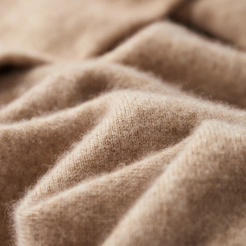Beige kashmir uldstof i nærbillede, viser blød tekstur og høj kvalitet. Perfekt til luksuriøse trøjer og tørklæder. Ideel til mode og design.