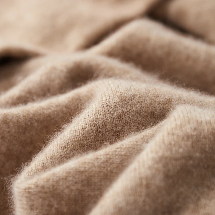 Beige kashmir uldstof i nærbillede, viser blød tekstur og høj kvalitet. Perfekt til luksuriøse trøjer og tørklæder. Ideel til mode og design.