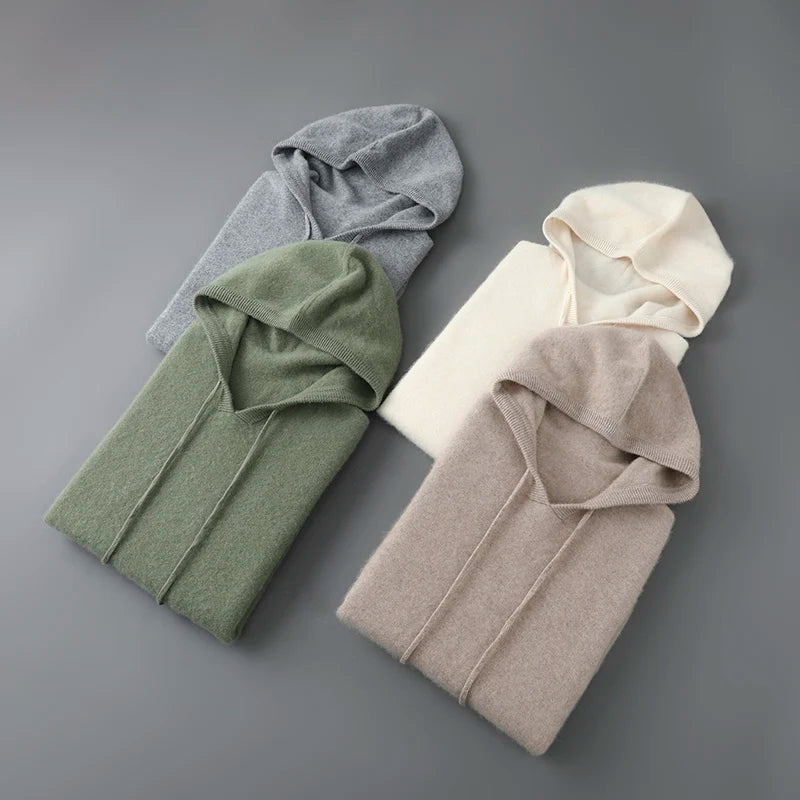 Fire foldede hættetrøjer i grå, grøn, beige og creme på grå baggrund. Bløde materialer, moderne design, perfekt til efterårsmode.