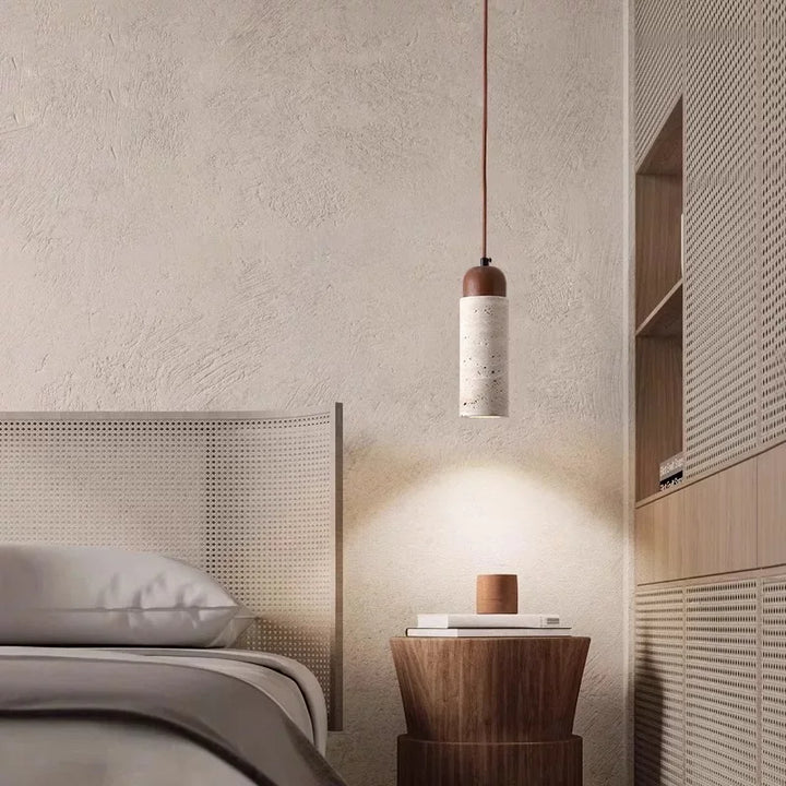 Moderne soveværelse med minimalistisk indretning, hængelampe i beton og træ, natbord i træ ved siden af seng med flettet sengegavl.