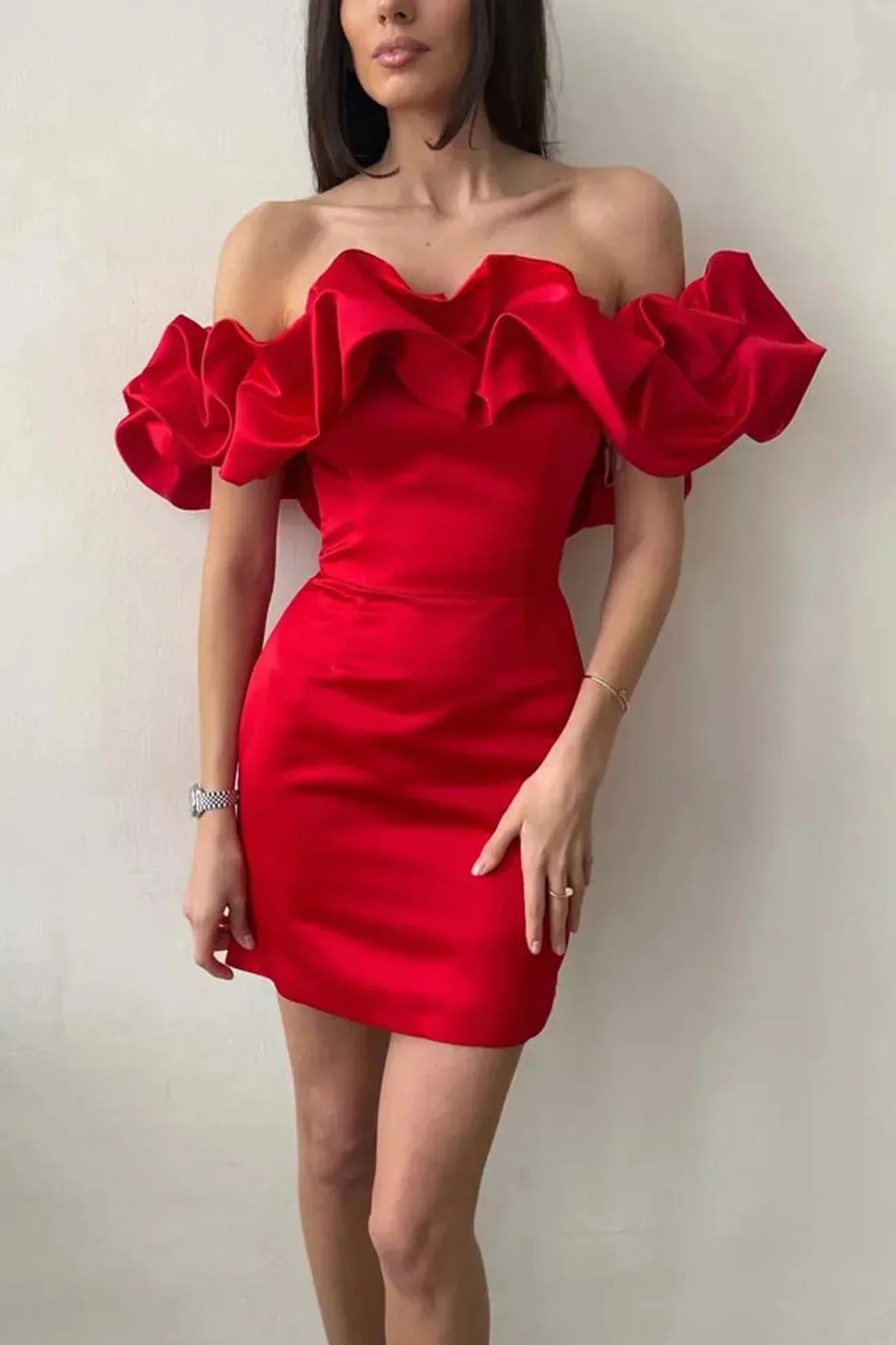 Kvinde i rød cocktailkjole med off-shoulder flæser, elegant design, perfekt til fest eller aftenbegivenheder. Trendy og stilfuldt look.