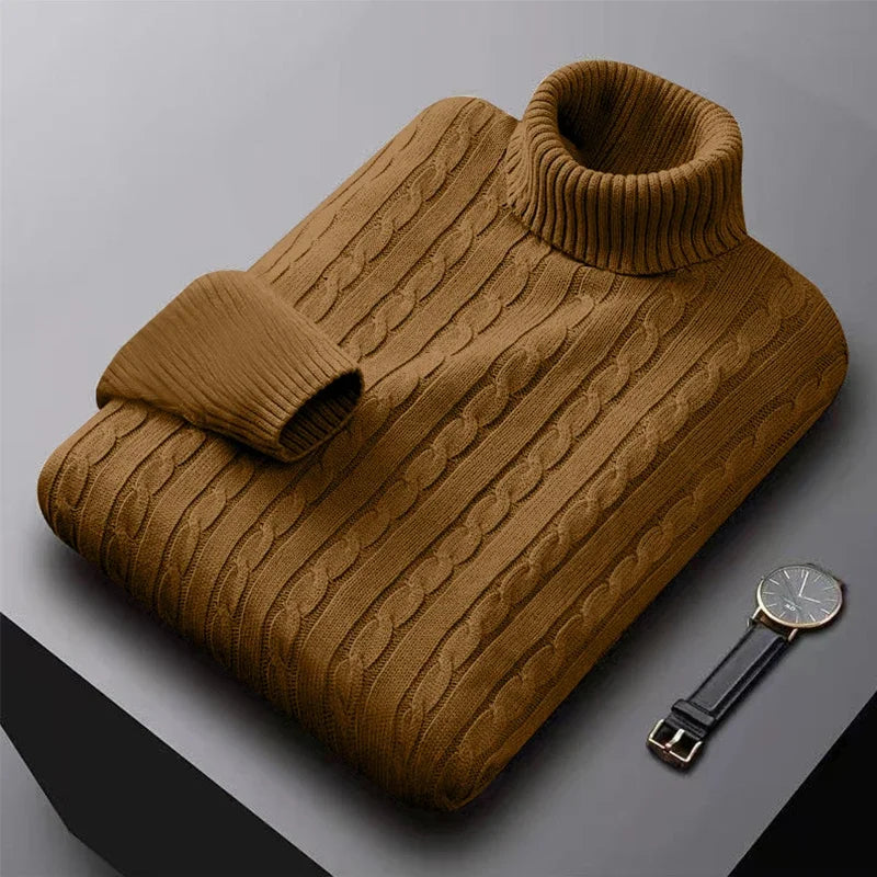 Brun kabelstrik rullekrave sweater på grå overflade ved siden af et elegant armbåndsur. Varm vintermode, herrestrik, stilfuldt design.