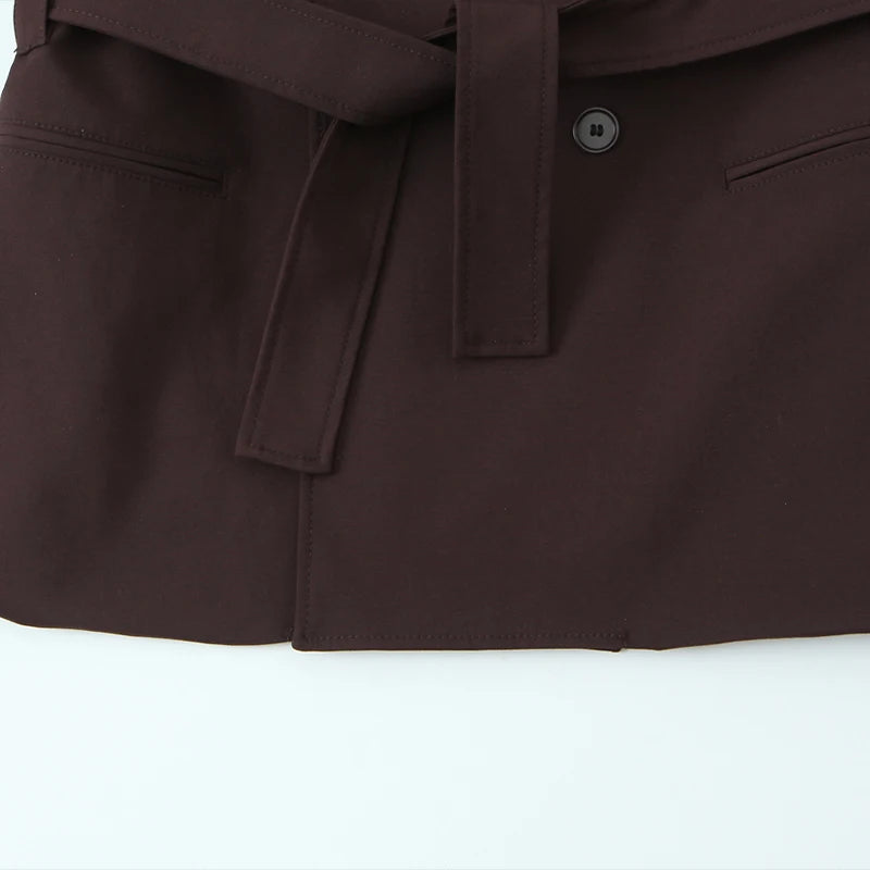 Mørkebrun trenchcoat med bælte og knapdetaljer, elegant design, velegnet til efterårsmode. Perfekt til stilfulde og moderne outfits.