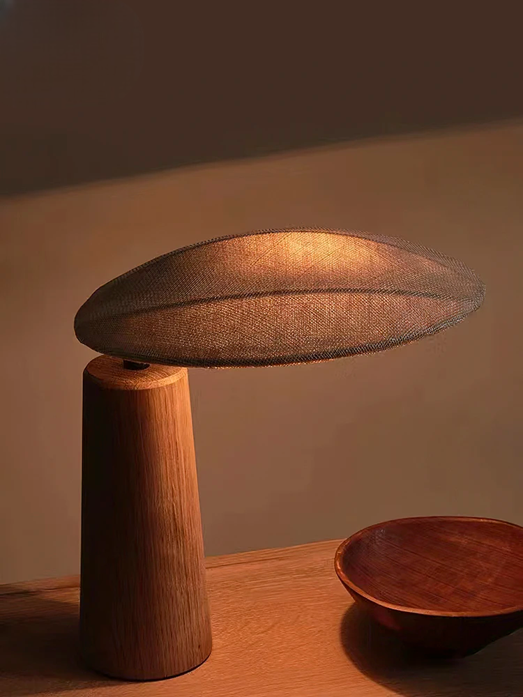 Moderne bordlampe i træ med oval skærm, minimalistisk design, varm belysning, ideel til stueindretning, skandinavisk stil, elegant og funktionel.