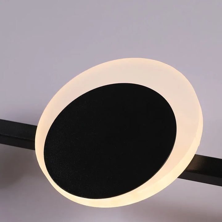 Moderne rund LED-væglampe med sort center og hvid lysring, minimalistisk design, energibesparende belysning til hjemmet.