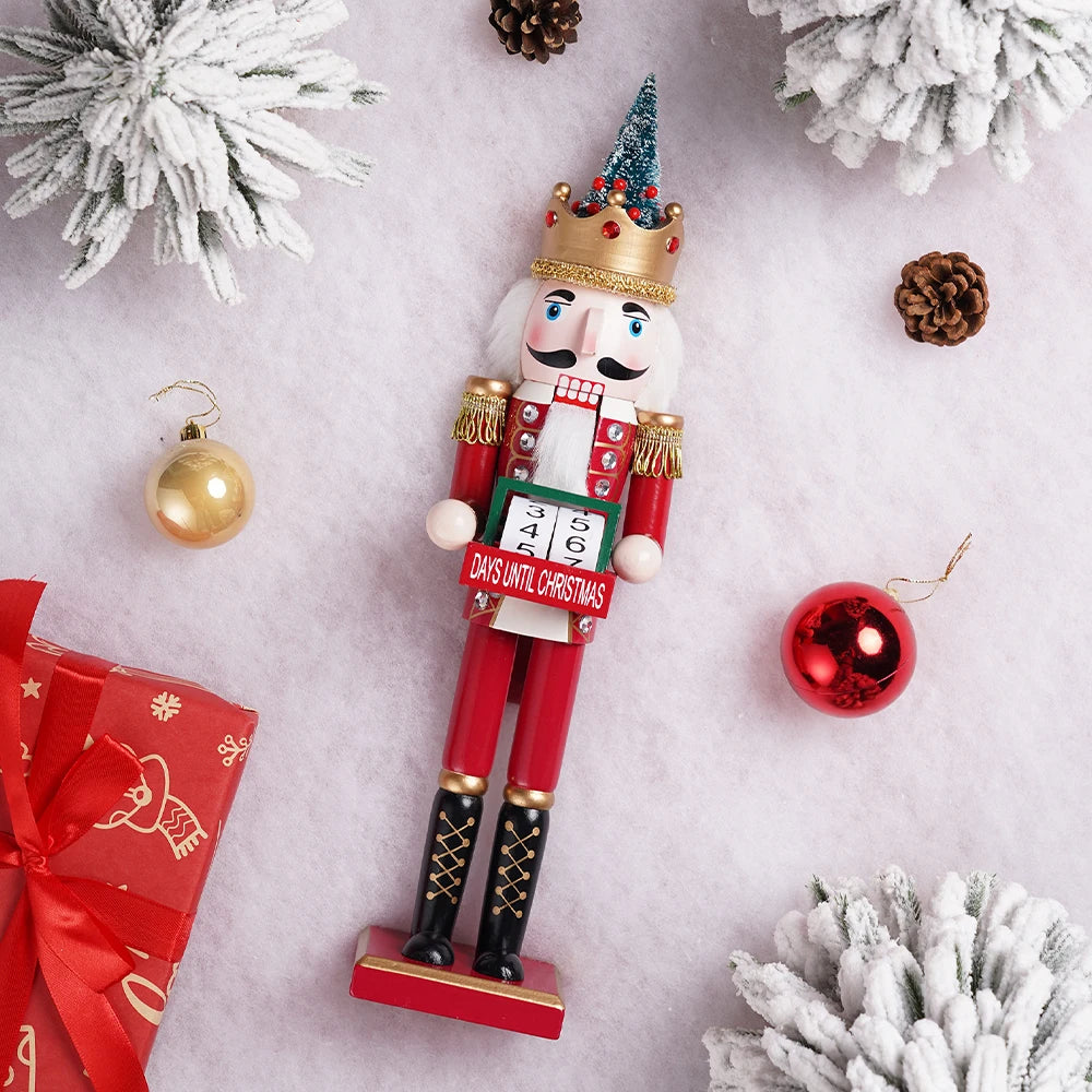 Jule-nøddeknækker med nedtællingskalender, omgivet af sneklædte grene, julekugler og gaveæske. Perfekt til juledekoration og nedtælling.