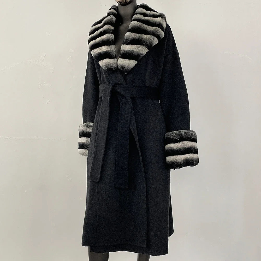 Sort frakke med bælte, pelskrave og pelsmanchetter i striber. Elegant vinterjakke til kvinder. Luksuriøs og stilfuld beklædning.