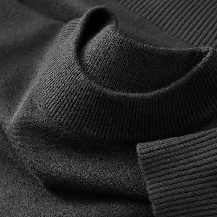 Sort kashmirtrøje med høj hals og ribstrikket krave. Luksuriøs, blød striktrøje til vintermode. Perfekt til stilfulde, varme outfits.