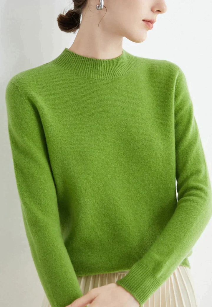 Kvinde iført grøn cashmere sweater, minimalistisk design, langærmet, rund hals. Perfekt til efterårsmode og stilfulde outfits.
