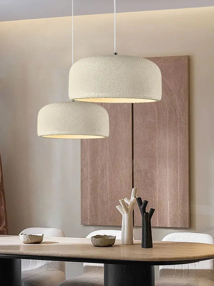 To pendellamper i moderne stueindretning med minimalistisk design, hænger over træbord. Beige nuancer, stilfuld belysning, skandinavisk stil.