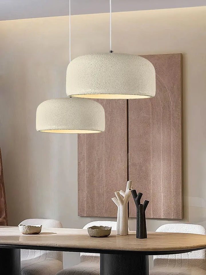 To pendellamper i moderne stueindretning med minimalistisk design, hænger over træbord. Beige nuancer, stilfuld belysning, skandinavisk stil.