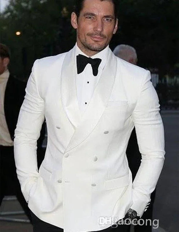 Mand i hvid smoking med sort butterfly, elegant aftenbeklædning, formel mode, udendørs baggrund, stilfuld herrebeklædning, klassisk look.