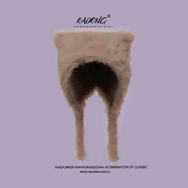 Plysset vinterhue med øreklapper, beige farve, fra Kadong Fashion 2022. Stilfuldt og varmt tilbehør til kolde dage.