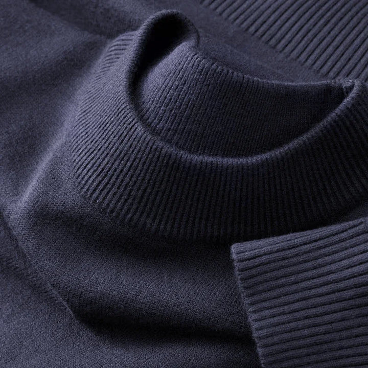 Mørkeblå rullekrave sweater i blødt strikmateriale, tæt på. Perfekt til vintermode, komfortabel og stilfuld beklædning til kolde dage.