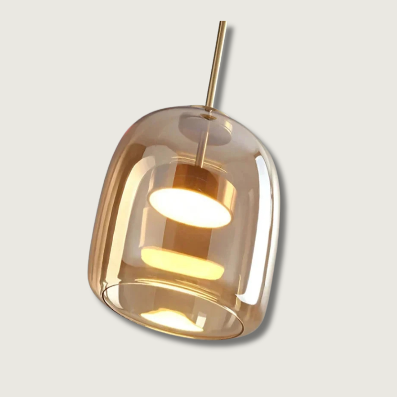 Moderne pendellampe i glas med gylden finish, elegant design, ideel til stue eller køkkenbelysning. Stilfuld og funktionel indretning.