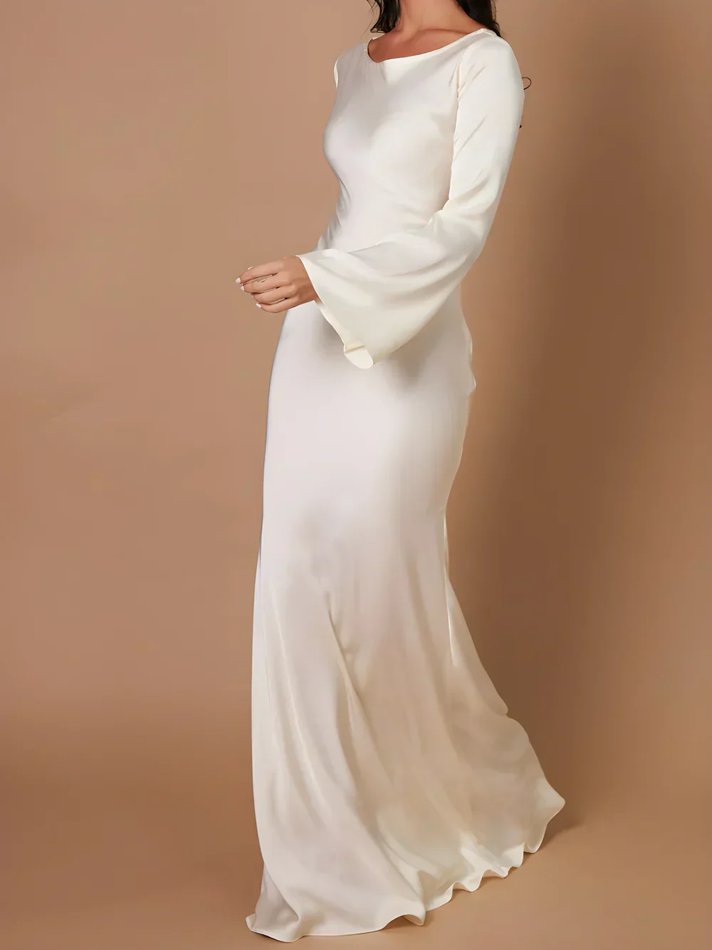 Elegant hvid langærmet kjole med klokkeærmer, perfekt til bryllup eller formelle begivenheder. Stilfuldt design i glat stof.