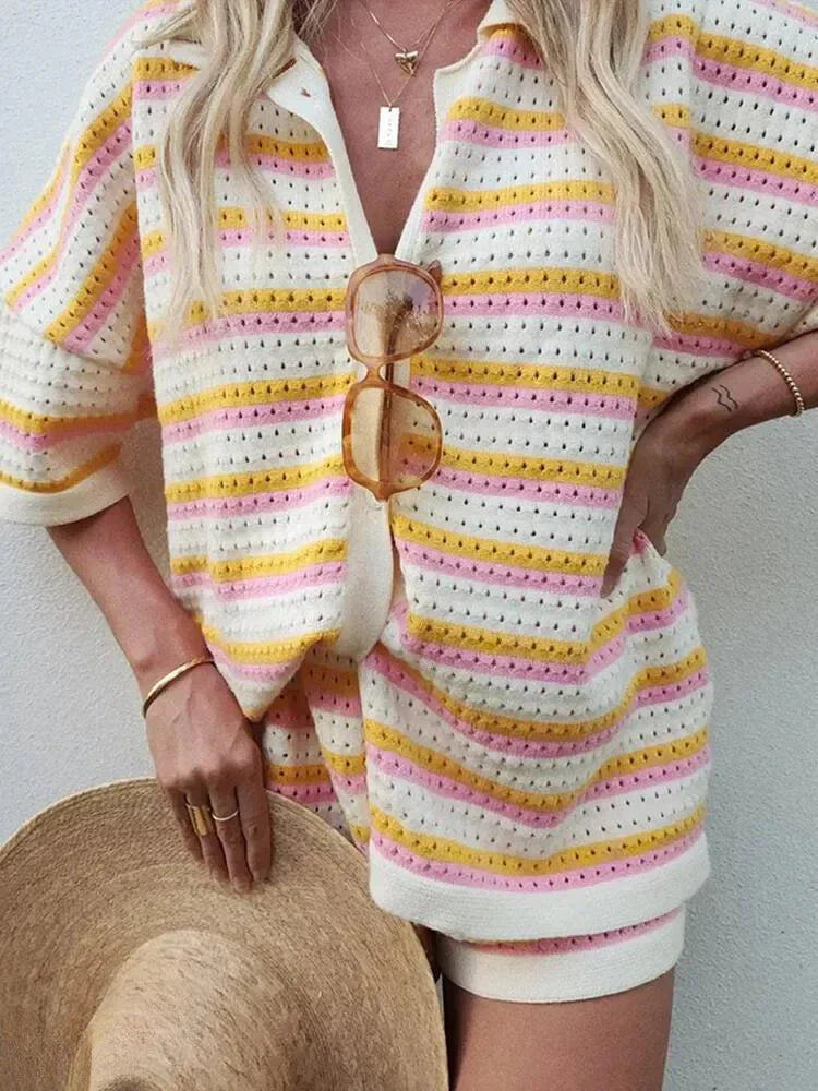 Dame i stribet sommeroutfit med gule og lyserøde nuancer, holder solbriller og stråhat. Trendy sommermode, afslappet stil, kvindetøj.