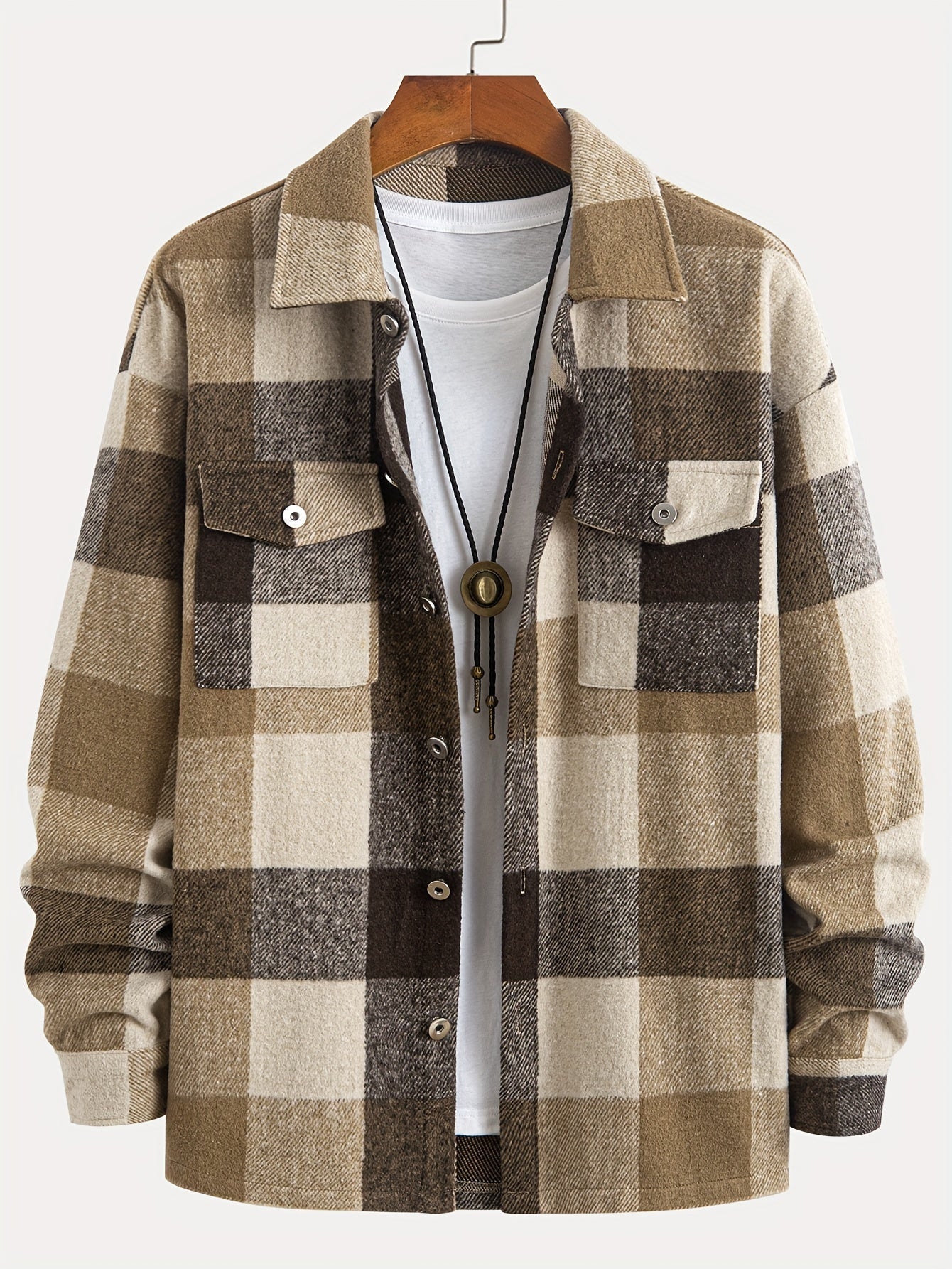 Brun og beige ternet flanneljakke med hvide knapper, to brystlommer og hvid T-shirt. Perfekt til herremode og afslappet efterårslook.