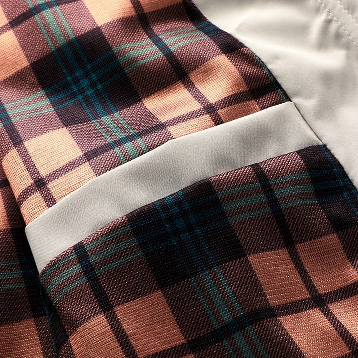 Brun og orange ternet stof med lomme, tæt på. Mønstret tekstil, skotskternet design, mode, tekstilindustri, detalje.