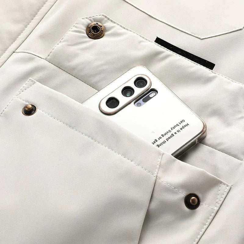 Hvid smartphone med tre kameraer i en beige jakkelomme. Moderne mobiltelefon, stilfuldt design, teknologi, modeaccessory.