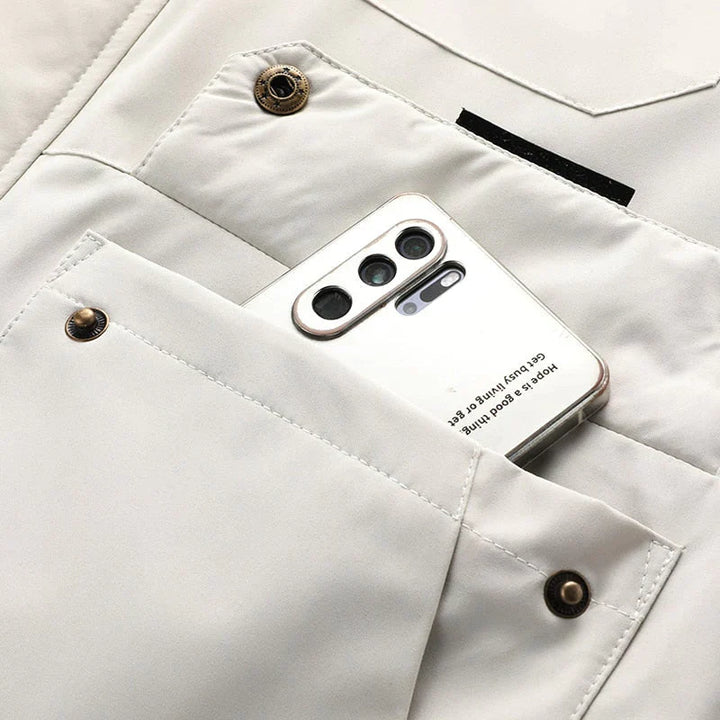 Hvid smartphone med tre kameraer i en beige jakkelomme. Moderne mobiltelefon, stilfuldt design, teknologi, modeaccessory.