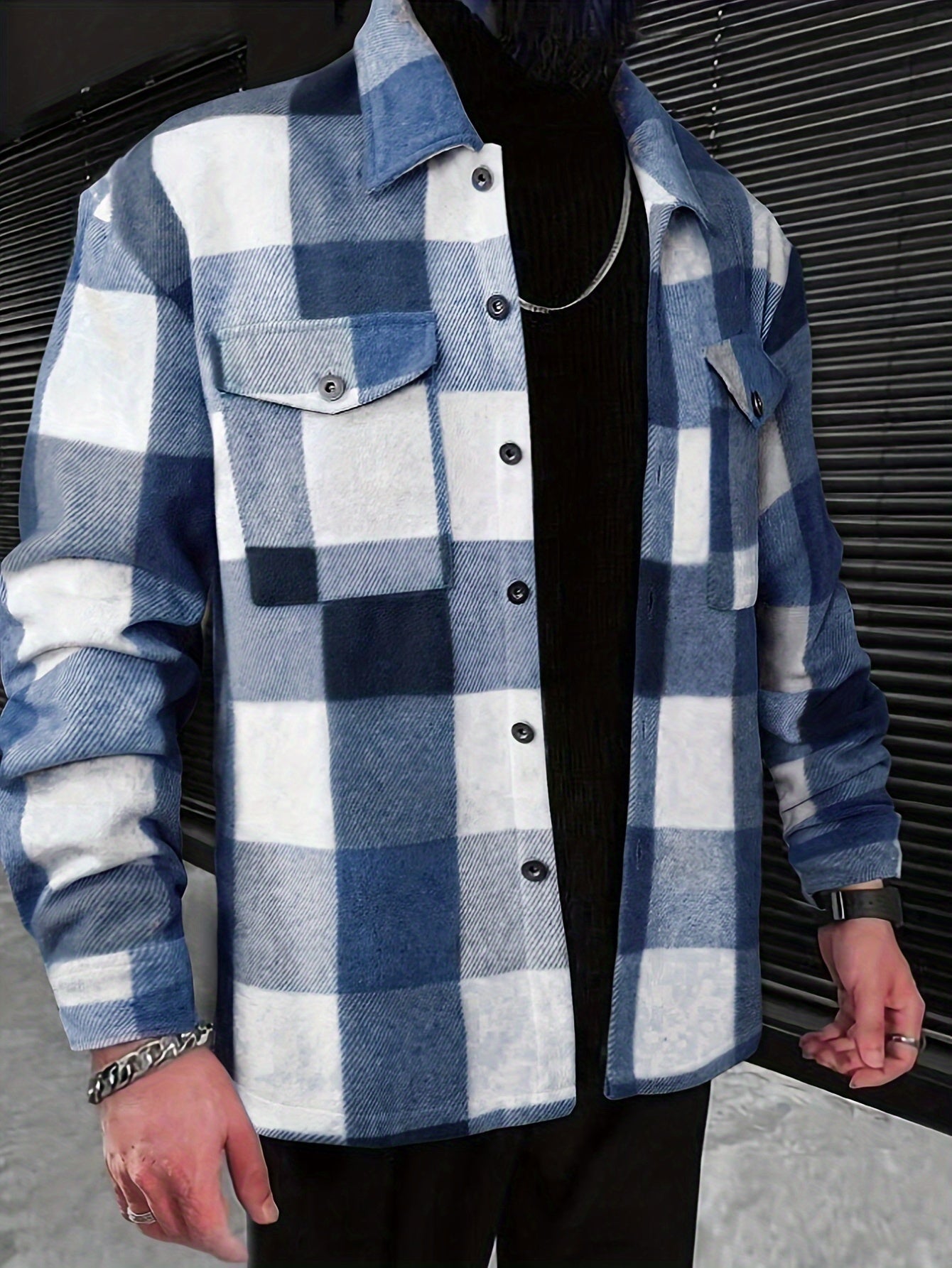 Mand iført blå-hvid ternet flanneljakke, sort trøje og sølvkæde. Moderne herremode, afslappet stil, trendy efterårslook.
