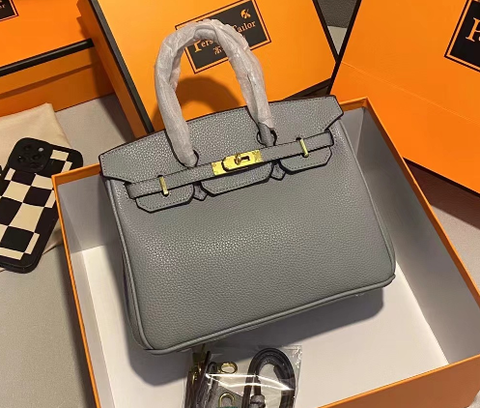 Grå Hermès Birkin taske i æske med orange emballage, luksusmode, ikonisk design, læderhåndtaske, eksklusiv stil, kvindetilbehør.
