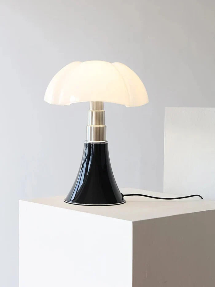 Sort og hvid bordlampe med svampeformet skærm på hvid piedestal. Moderne design, indendørs belysning, stilfuld indretning, minimalistisk lampe.