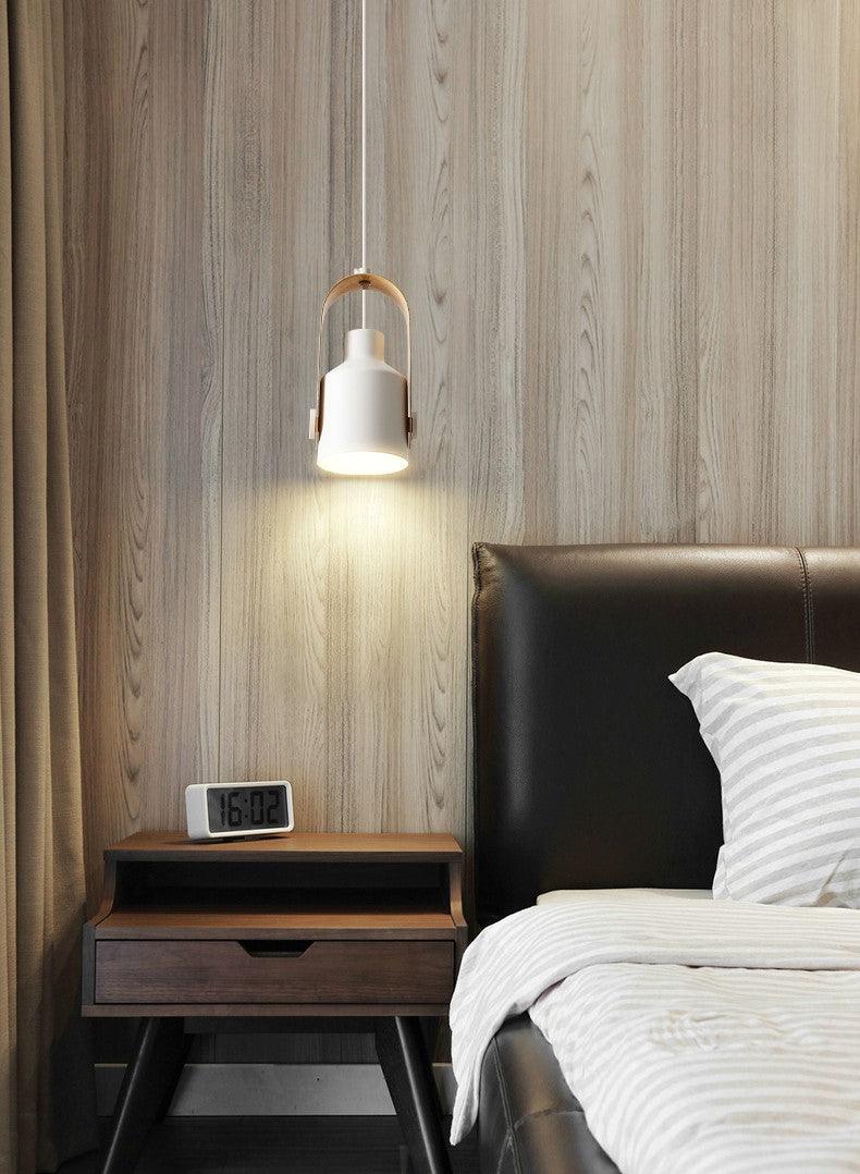 Moderne soveværelse med trævæg, seng med læderhovedgærde, natbord, digitalt vækkeur og stilfuld hængelampe. Skandinavisk indretning.
