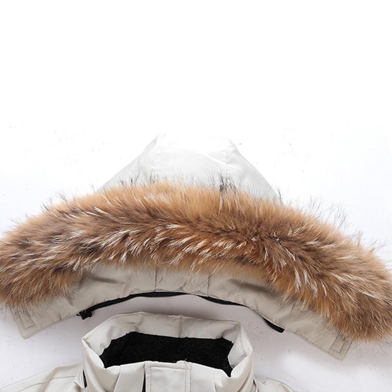 Hvid vinterjakke med hætte og brun pelskant. Varm og stilfuld overtøj til koldt vejr. Ideel til vintermode og udendørs aktiviteter.