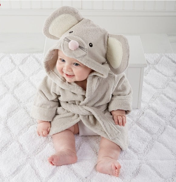 Baby iført en grå badekåbe med museører, sidder smilende på et hvidt tæppe. Sødt babytøj, nuttet musekostume, babyfotografi.