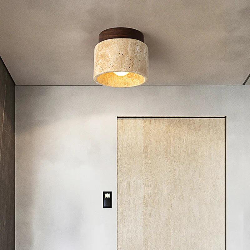 Loftlampe i moderne design med beige skærm og trædetaljer, monteret på et minimalistisk loft. Perfekt til stilfuld belysning i hjemmet.